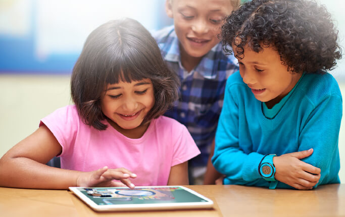 Elementary school students using an iPad to practice foundational listening and literacy skills on the HearBuilder software platform.